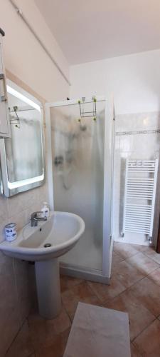 een witte badkamer met een wastafel en een douche bij Country Esmera in Desenzano del Garda