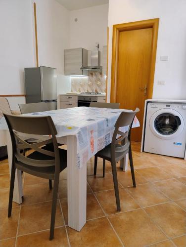 a kitchen with a table and chairs and a washing machine at Al VICO TREDICI in Gaeta