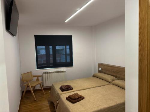 a bedroom with a bed and a window at Pensión Río Sarria in Sarria