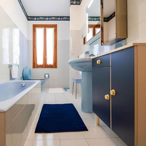 a bathroom with a blue sink and a blue rug at Vista Mare Lido Avola in Avola
