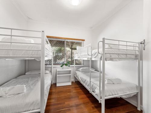 two bunk beds in a white room with a window at Margs In Mandurah- Classic Family Holiday Abode! in Dawesville