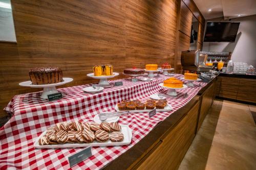 a table with cakes and other desserts on it at Hotel Laghetto Bento in Bento Gonçalves