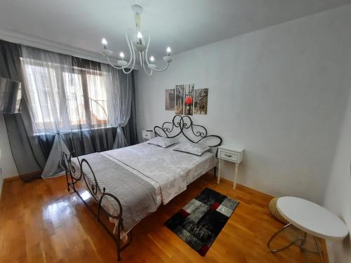 una camera con letto, tavolo e lampadario a braccio di Negruzzi 2 bedrooms a Chişinău