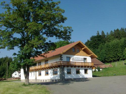 ein Gebäude mit einem Baum davor in der Unterkunft Ferienhof Jägersteig in Waldmünchen