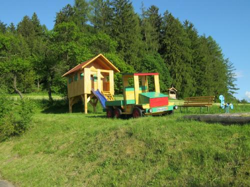 Ein kleines Haus und ein Spielzeugauto auf einem Feld in der Unterkunft Ferienhof Jägersteig in Waldmünchen
