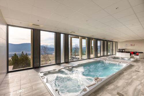 une baignoire jacuzzi dans une chambre avec fenêtres dans l'établissement Les Terrasses Sur Les Angles - Vue Montagne, aux Angles