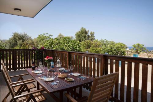 a wooden table with glasses and food on a deck at Laftiras Sea View Home in Archangelos