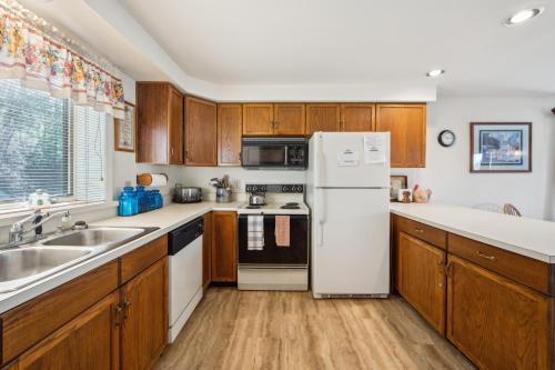 a kitchen with wooden cabinets and a white refrigerator at 11D - Spacious & Family-Friendly Getaway in North Creek