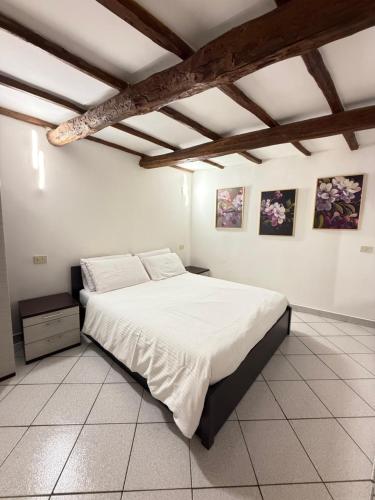 a bedroom with a large bed with white sheets at Casa Cost 3 in Vetralla