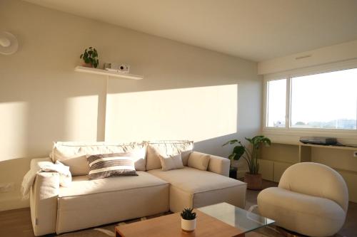 un salon avec un canapé et une chaise dans l'établissement Spacious apartment near Belleville, à Paris