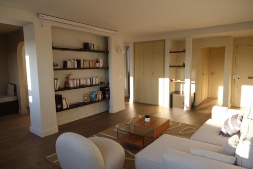 un salon avec un canapé blanc et une table dans l'établissement Spacious apartment near Belleville, à Paris
