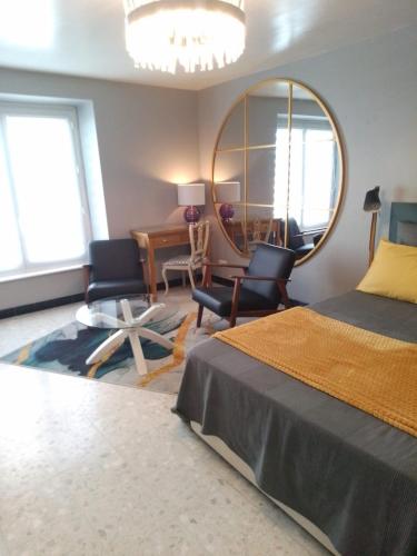 - une chambre avec un lit et un miroir rond dans l'établissement T1bis, 100m de la belle plage de Morgat, à Crozon