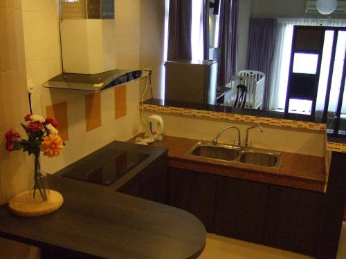 a kitchen with a sink and a vase of flowers at City Times Hotel in Kuantan