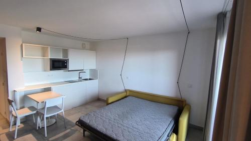 une petite pièce avec un lit et une table dans l'établissement Oustaou-Studio Bloom -Le Spot, à La Ciotat