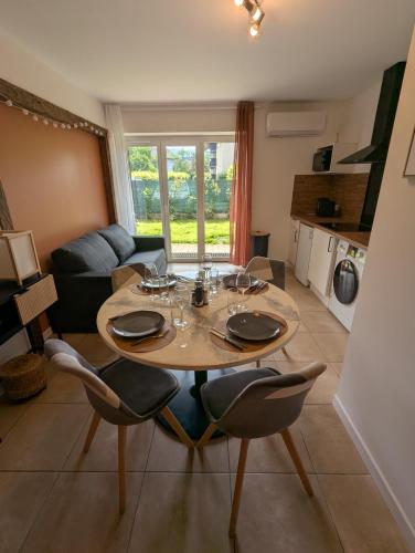 un salon avec une table et des chaises en bois dans l'établissement Élégant et calme avec clim et jardin privé - Appartement Terracotta, à Thonon-les-Bains