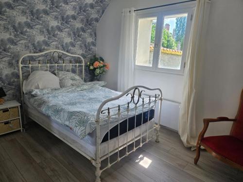 un lit blanc dans une chambre avec une fenêtre dans l'établissement Maison dans hotel particulier 18eme, wifi, piscine chauffée, à Château-Thierry