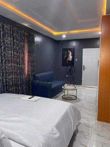 a bedroom with a bed and a chair and a table at Umbrella Properties hotels and apartments - Moniya in Ibadan