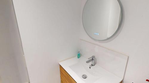 une salle de bain avec un lavabo et un miroir dans l'établissement Marechal Joffre - RDC - Grand F2, au Havre