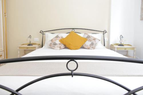 Una cama con una almohada amarilla encima. en Maison Conca DOro, en Roma