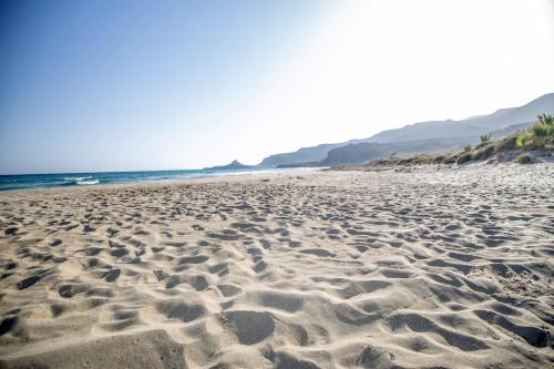 a sandy beach with the ocean in the background at Amatu Villa (Athena) in Xerokampos
