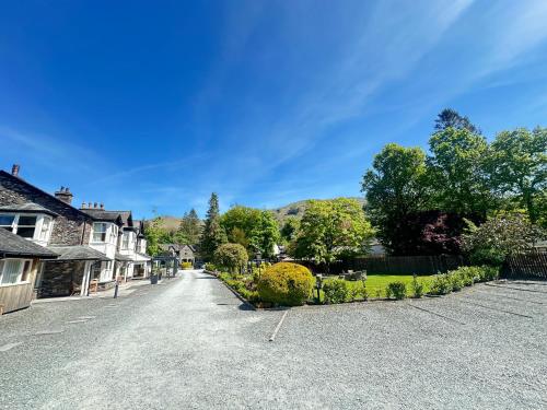 a street in a village with houses and trees at Bridge House Hotel & Silver Howe View Cottage in Grasmere