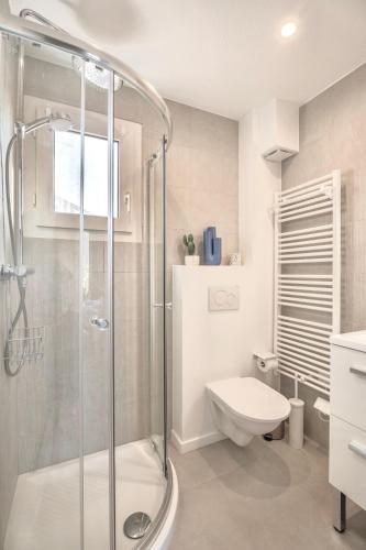 une salle de bain blanche avec douche et toilettes dans l'établissement Petite maison pour 6 - jardin clim piscine parking, à Théoule-sur-Mer