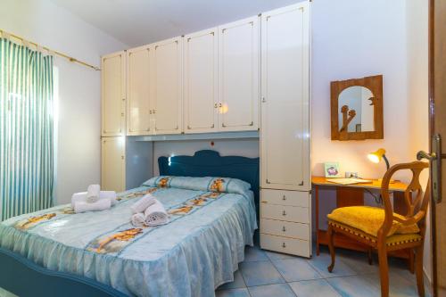 a bedroom with a bed and a desk and a chair at Smeraldo Beach in Santa Teresa Gallura