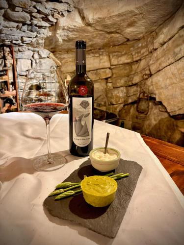 a bottle of wine and a glass on a table at Bed & Breakfast Casa Marinella in Lenna