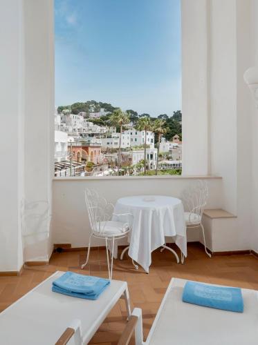 a room with a table and chairs and a window at Hotel Quisisana in Capri