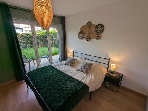 une chambre avec un lit et une grande fenêtre dans l'établissement Confortable et moderne avec clim et jardin privé - Appartement Sauge, à Thonon-les-Bains