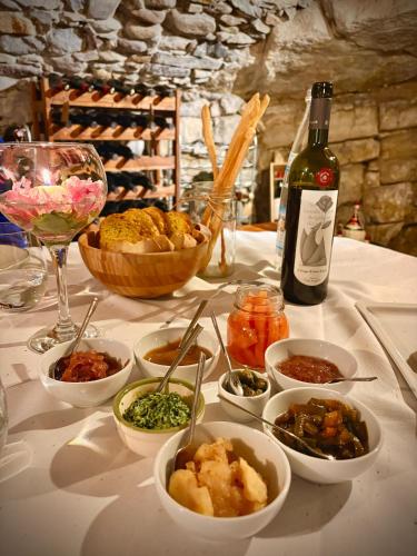 a table with bowls of food and a bottle of wine at Bed & Breakfast Casa Marinella in Lenna