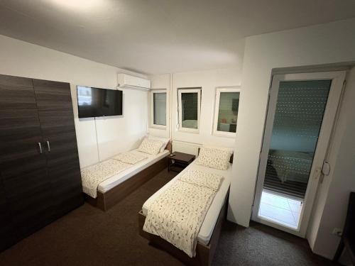 a small room with two beds and a tv at Hotel Avanti in Zenica