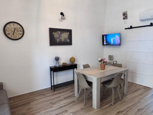 una sala da pranzo con un tavolo e un orologio a parete di La Casa sul Corso a Talsano
