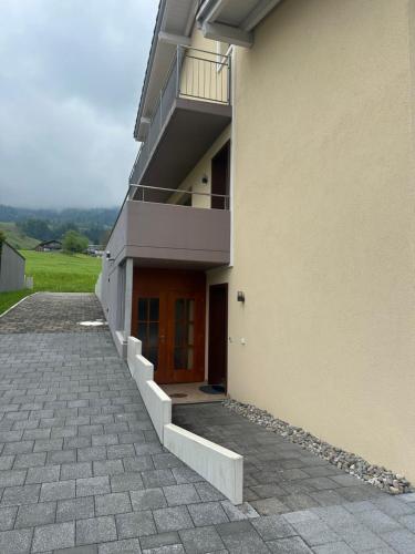 a building with a balcony and a door on it at Komfortable Ferienwohnung in Beckenried, Nidwalden in Beckenried
