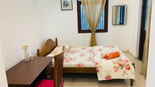 a room with a table and a bed with a pillow at catherine villa in Ja-Ela