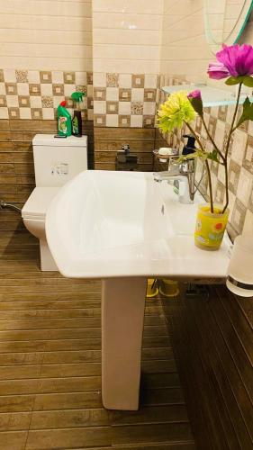 a bathroom with a sink and a toilet and flowers at catherine villa in Ja-Ela