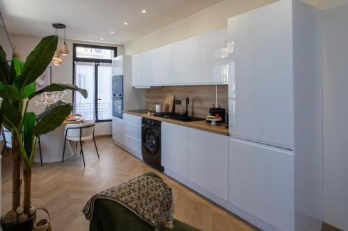 une cuisine avec des armoires blanches et une table dans une pièce dans l'établissement #52 Etoile Suite ,Central, Balcony, AC-5 min P Massena, à Nice