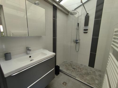 une salle de bain blanche avec un lavabo et une douche dans l'établissement Appart 109, Port Soleil au village naturiste, au Cap d'Agde