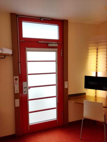 a red door in a room with a desk at Orange Wings Wiener Neustadt in Wiener Neustadt
