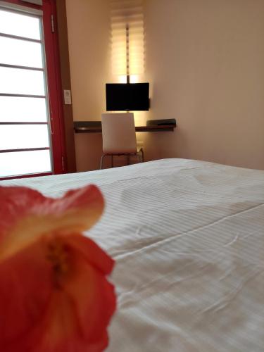 a bedroom with a white bed with a red flower at Orange Wings Wiener Neustadt in Wiener Neustadt