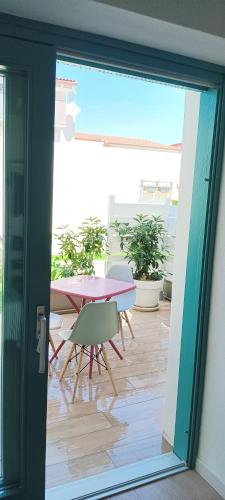 a sliding glass door leading to a patio with a table and chairs at Eos affittacamere in Castelsardo