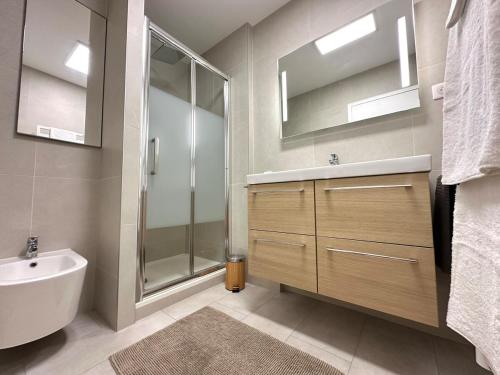 une salle de bain avec un lavabo, une douche et une baignoire dans l'établissement Vue mer et plage à pied, à Capbreton