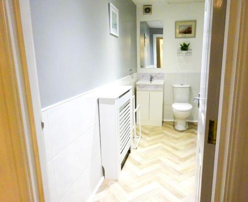 a bathroom with a toilet and a sink at Wigan Central Executive Apartments I Family Rooms I Free Parking in Wigan