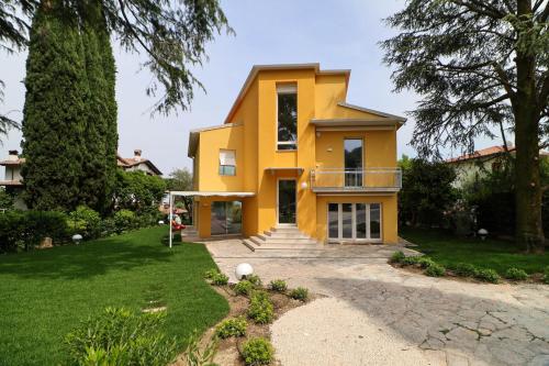 a yellow house with a driveway at La Gialla Attico dAmore in Padenghe sul Garda