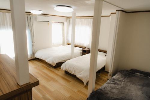 a bedroom with two beds and a window at Cozy Pad in Tokyo