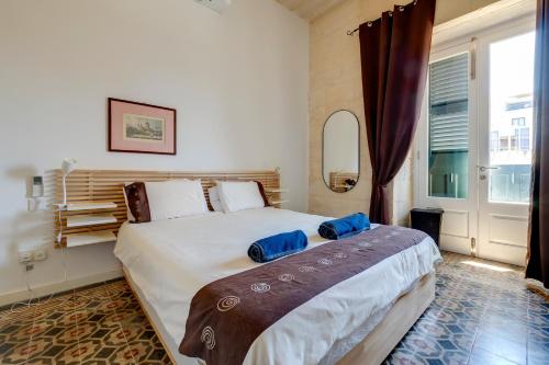 une chambre avec un grand lit avec des oreillers bleus dessus dans l'établissement Exclusive 2BR Valletta Apartment, à La Valette