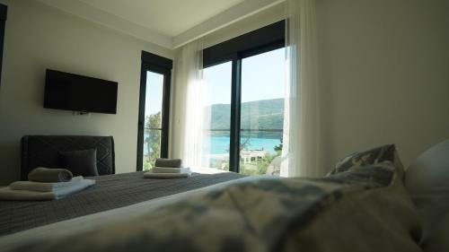 イガロにあるARGUS apartmaniの大きな窓のあるベッドのある寝室