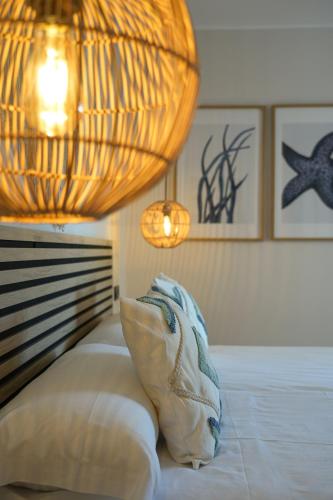 a bedroom with a bed with a chandelier and a bed sidx sidx sidx at Apartamentos Ses Veles in Cala Llonga