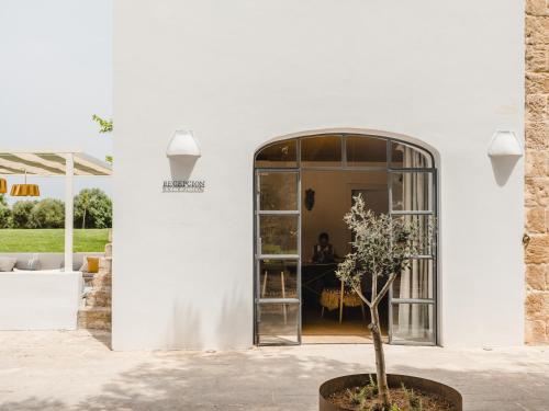 a tree in a pot in front of a building at Amagatay Luxury Boutique Hotel - Adults Only in Alaior