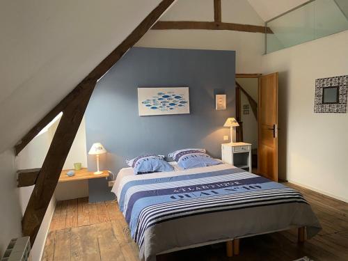 une chambre avec un grand lit aux murs bleus dans l'établissement Fleur de Sel, longère au calme , proche mer et plages, à Assérac